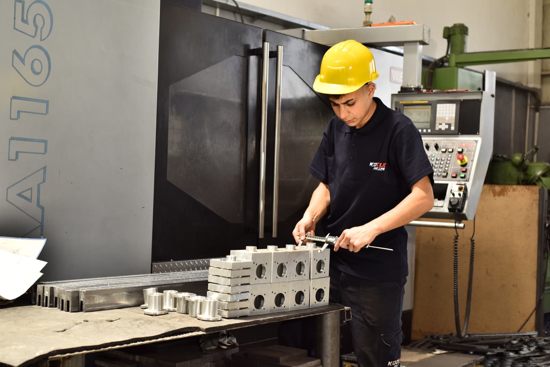 Üretilen metal parçanın ölçümünü yapan KONCLK Makine çalışanı
